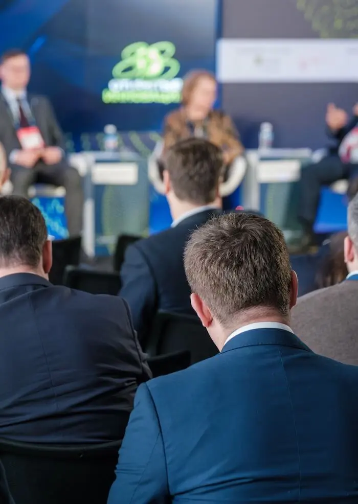 Business conference attendees seated listening