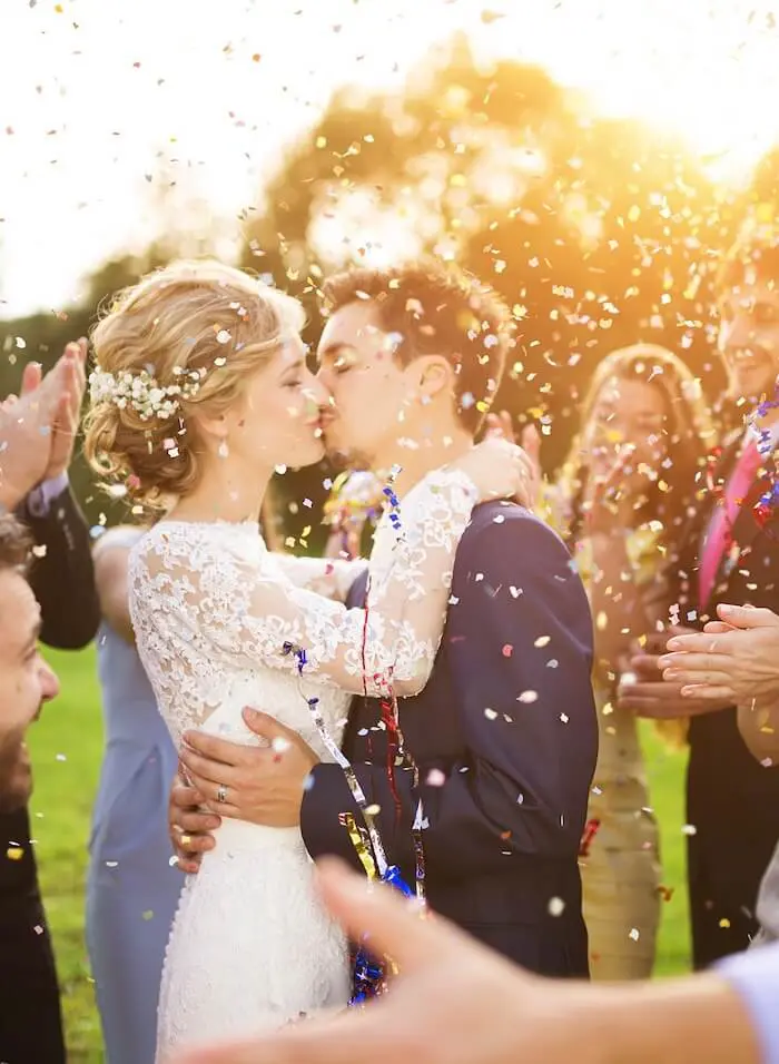 Wedding couple kissing with confetti