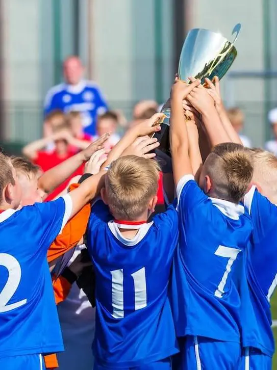 Kids celebrating soccer victory trophy