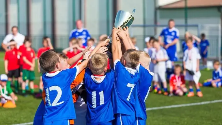 Kids celebrating with soccer trophy