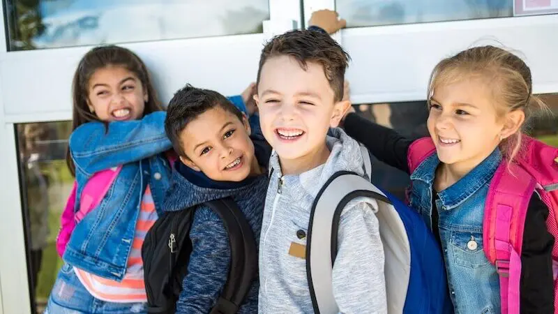 Happy children with backpacks smiling